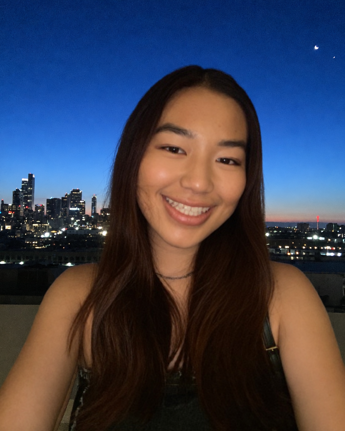 Jasmine Ang smiling against a moonlit city skyline
